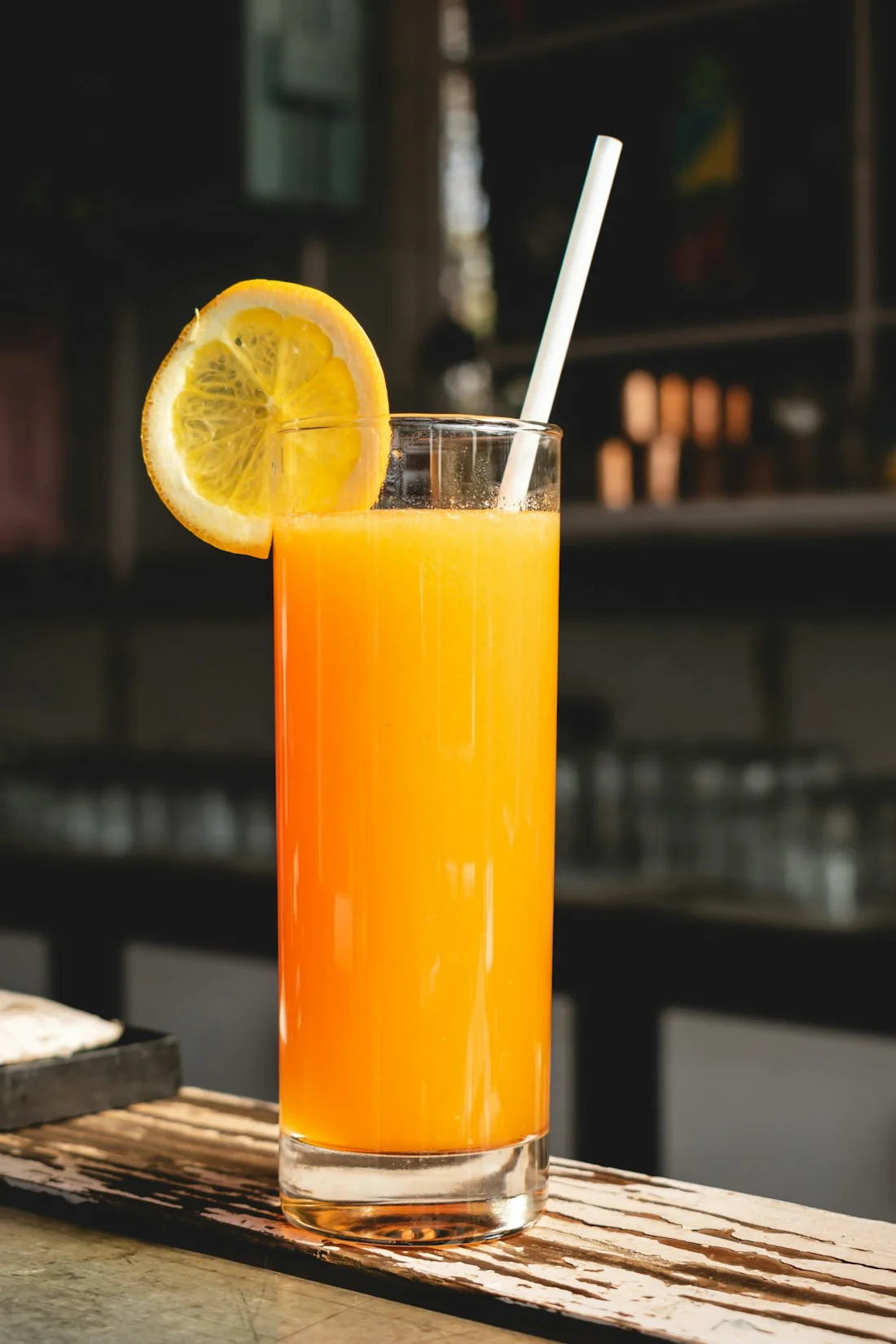 Un verre de jus d’orange frais dans une lumière ensoleillée, photographie illustrative.